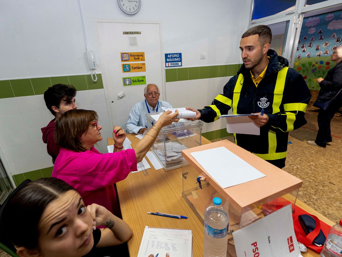 Foto: Un cartero entregando a la presidenta de una mesa electoral el voto por correo el pasado 28-M. (EFE/Marcial Guillén)