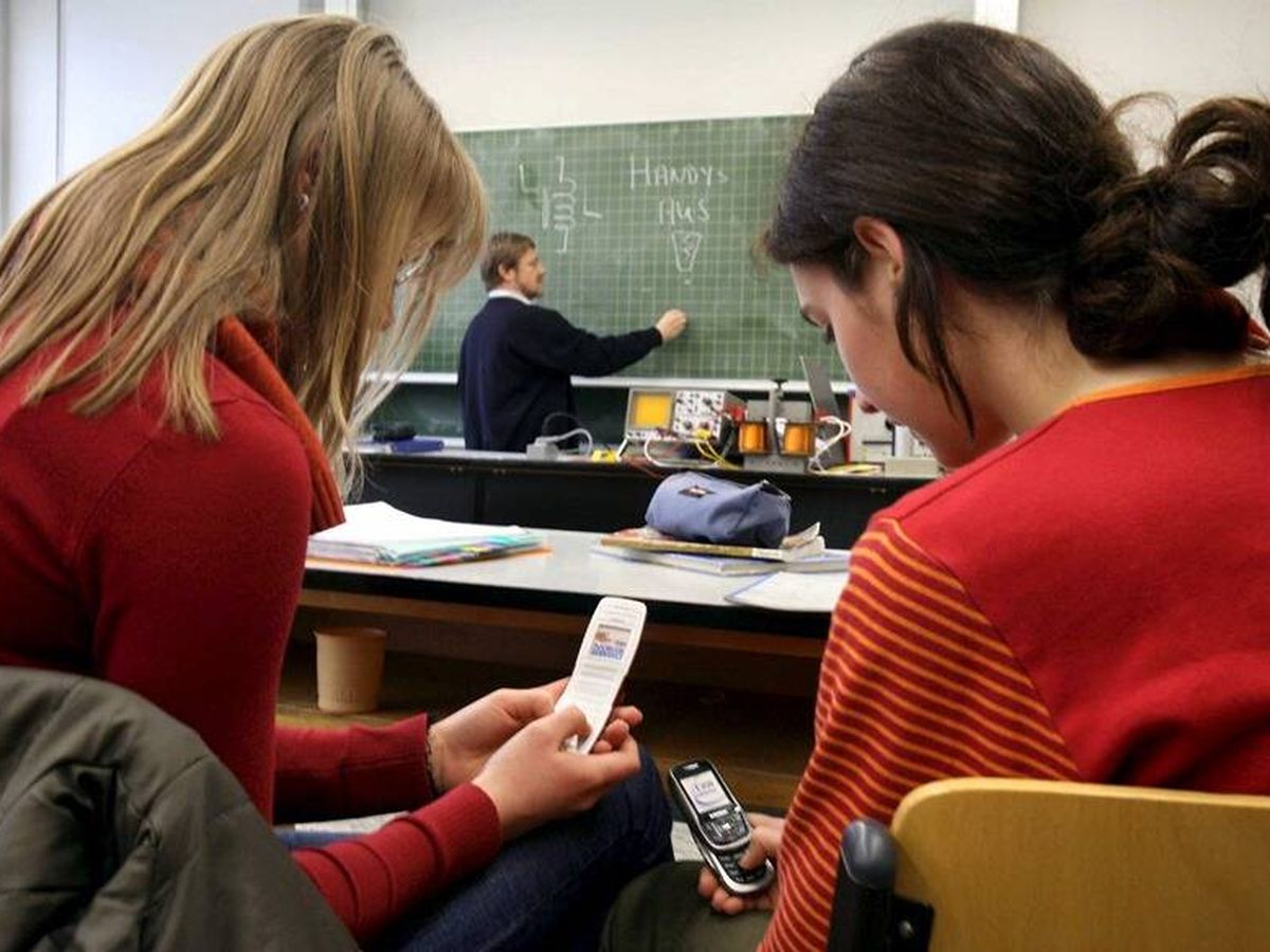 Foto: Adolescentes usando el móvil en el aula. (EFE/Marcus Fuerer)