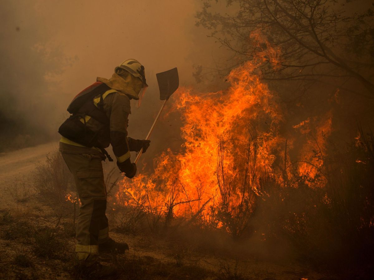 Foto: Un bombero forestal realiza labores de extinción en el incendio forestal de Rairiz de Veiga. (EFE)