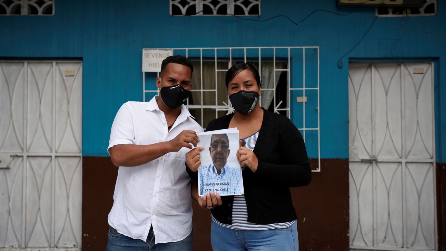 Jimmy Centeno y su hermanda Dolores sujetan una foto de su padre, Cerafin, cuyo cuerpo no han sido capaces de encontrar desde que murió por coronavirus hace dos meses, en Guayaquil. (Reuters)