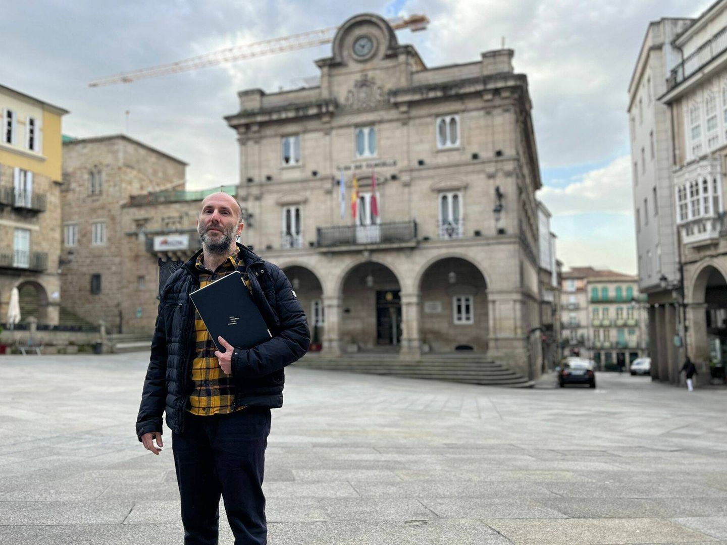 Gonzalo Pérez Jácome, frente al ayuntamiento de Ourense y una grúa de fondo. El alcalde está especialmente orgulloso de las obras que se están llevando a cabo en la ciudad. (A. F.)