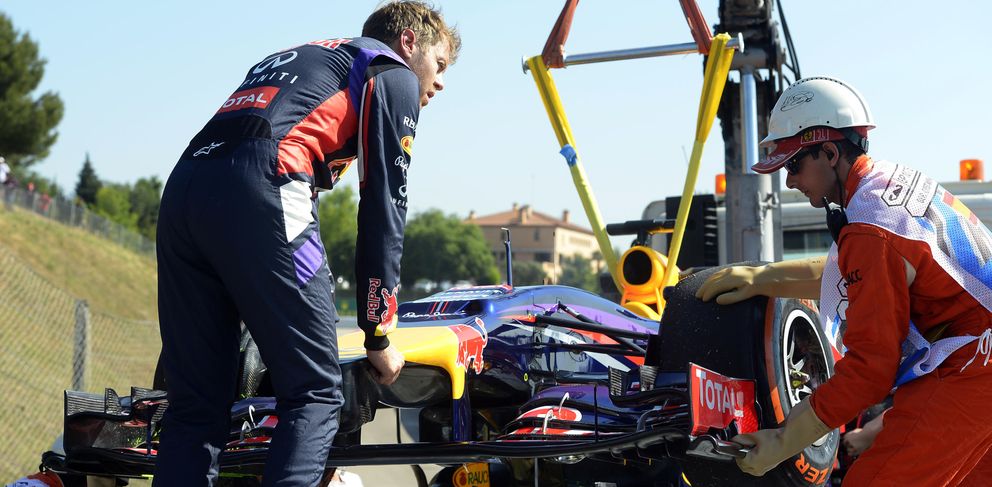 Vettel ayuda a remolcar el RB 10 en el GP de España. (AP)