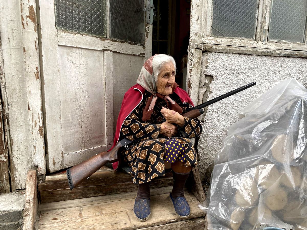 Foto: Una anciana con su escopeta en la puerta de su casa en Stepanakert, la capital del enclave separatista de Nagorno Karabaj disputada por Azerbaiyán y Armenia. (EFE)