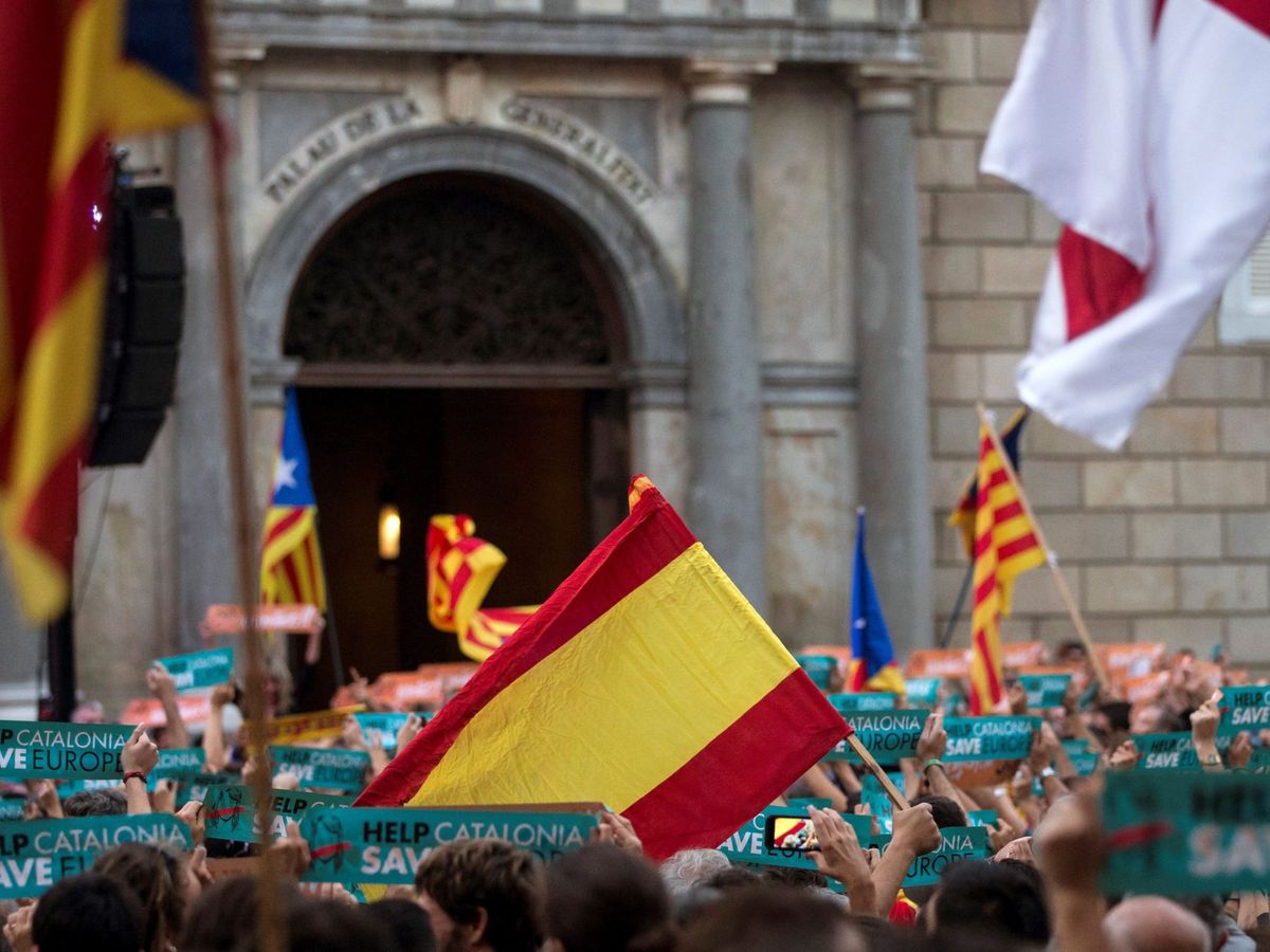 Foto: Manifestantes con banderas españolas y esteladas en la plaza Sant Jaume de Barcelona durante la declaración de independencia en 2017. (EFE/Quique García)