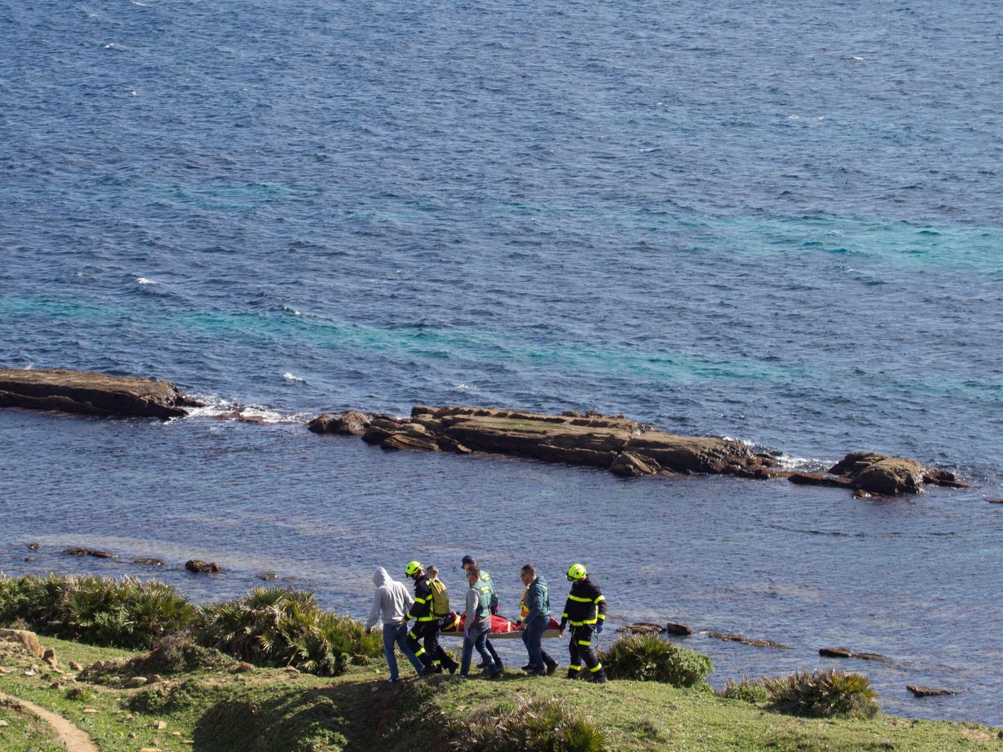 Un momento del traslado del cuerpo, hallado en la costa de Tarifa (Cádiz), de uno de los marineros que viajaban en el pesquero Rúa Mar. (EFE)