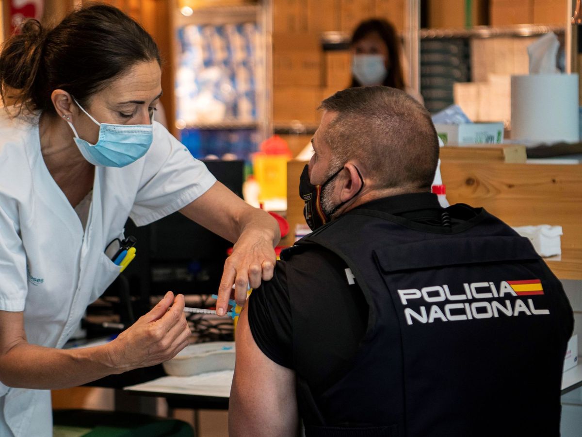 Foto: Un agente de la Policía Nacional recibe una dosis de la vacuna contra el covid-19 en el Hospital Son Espases, en Mallorca. (EFE)