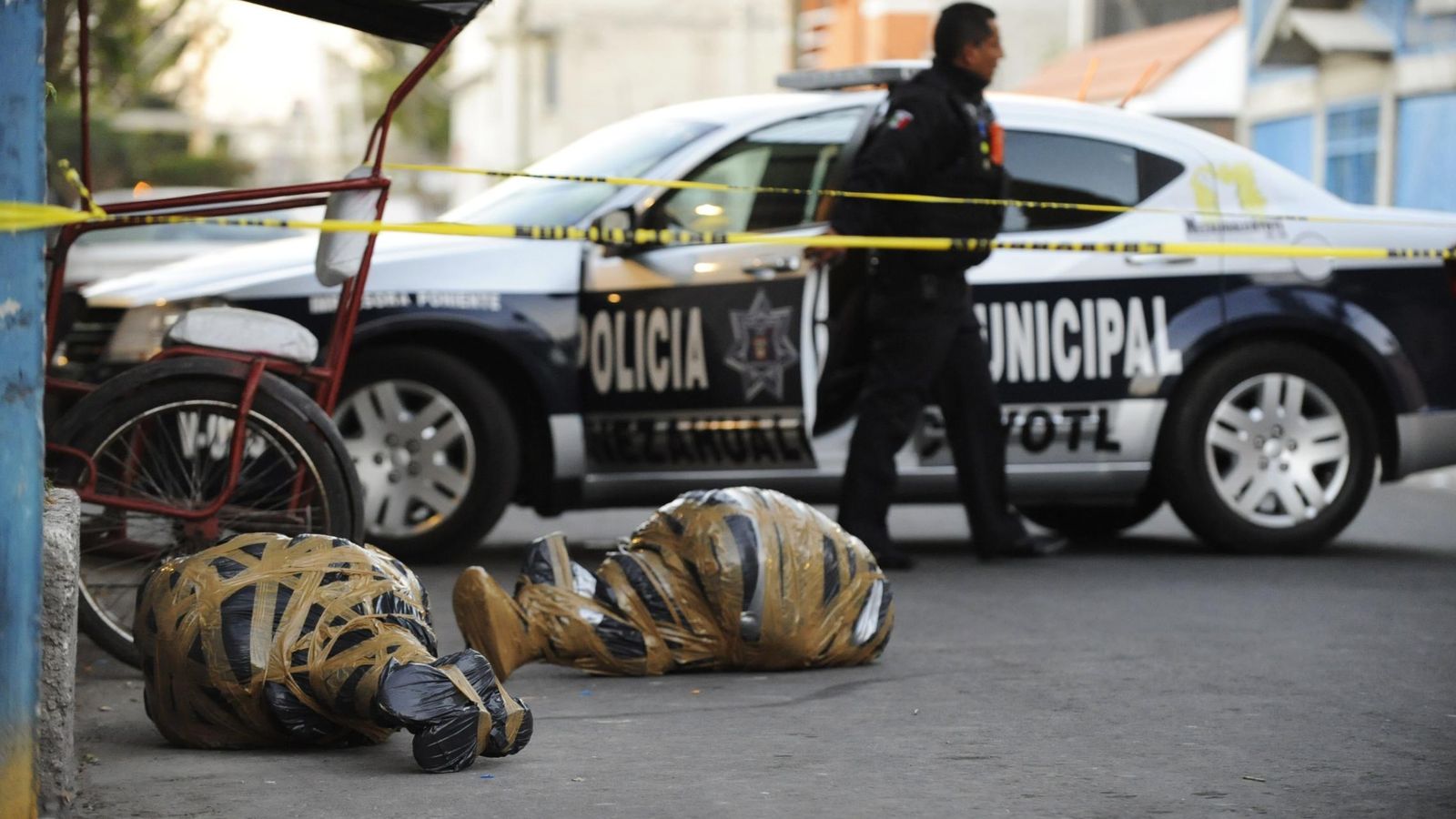 Foto: Un oficial de policía cerca de los cadáveres de dos personas asesinadas en Nezahualcoyotl, México (Reuters)