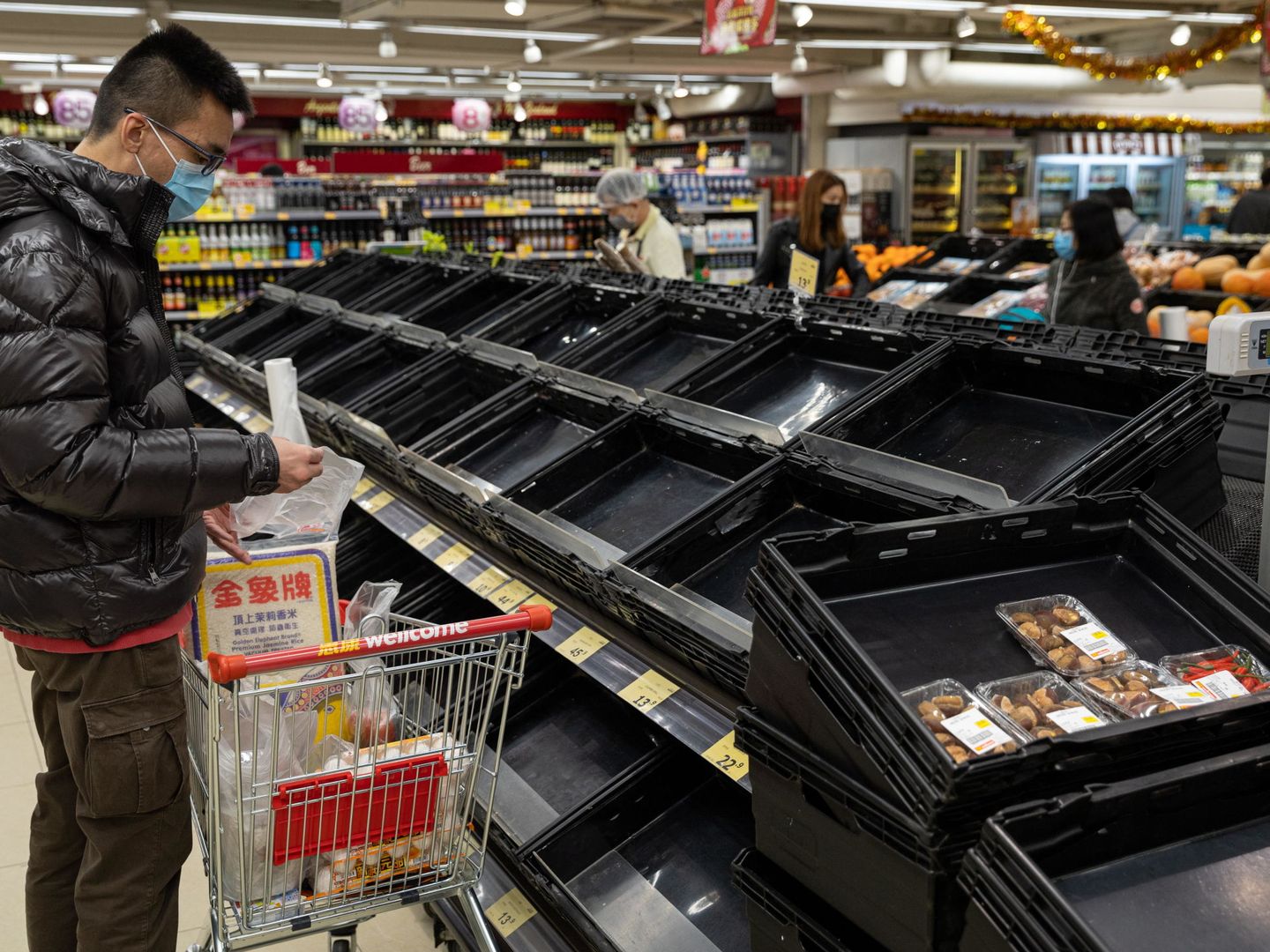 Un ciudadano de Hong Kong realiza la compra en un supermercado luciendo una mascarilla. (Reuters)