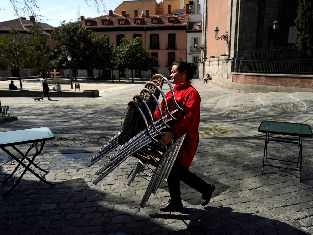 Foto: Una mujer guarda una terraza en un bar de Madrid. (Reuters)