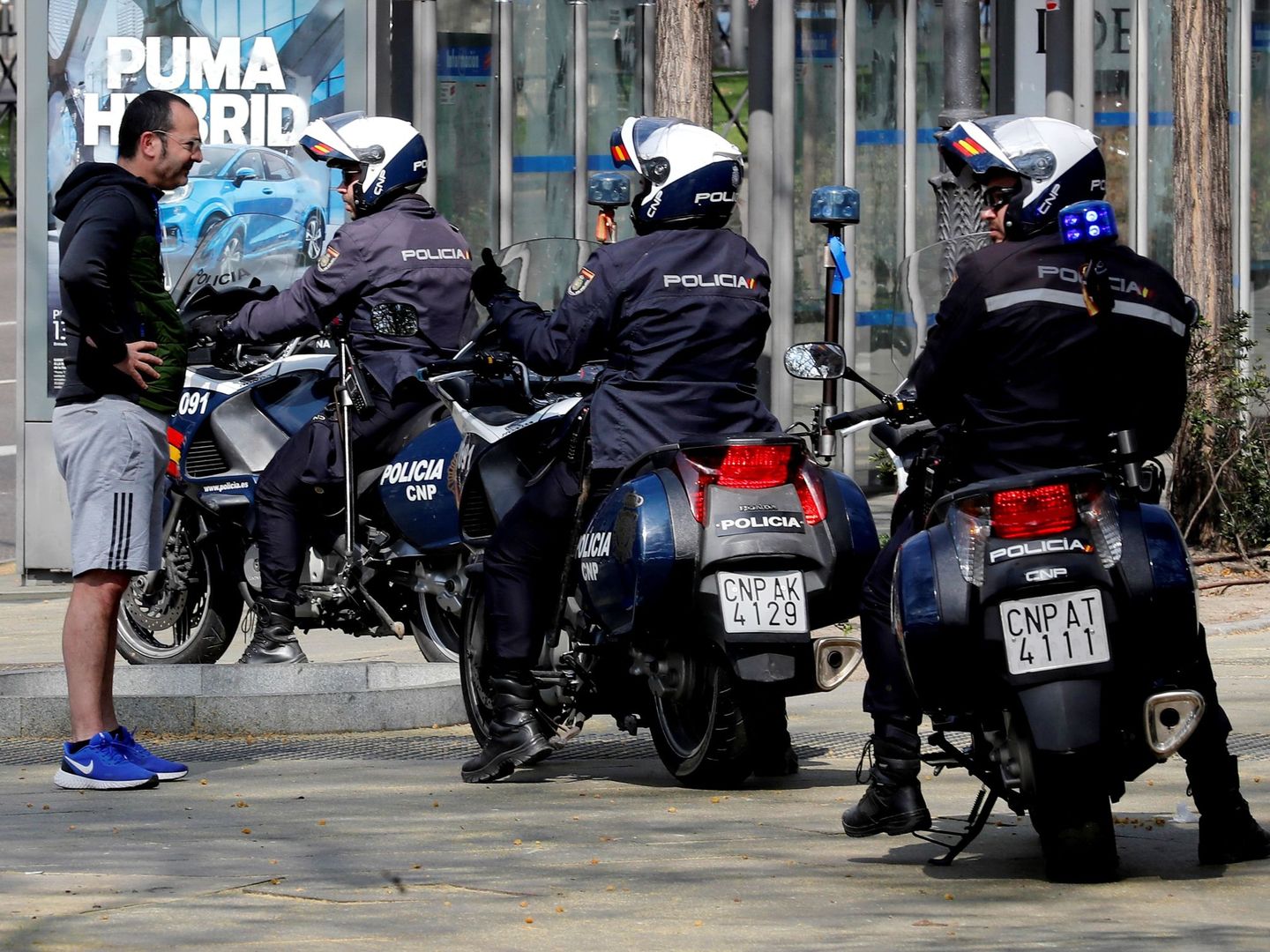 Unos policías informan a un viandante en el Paseo del Prado, en Madrid de que debe volver a casa. (EFE)