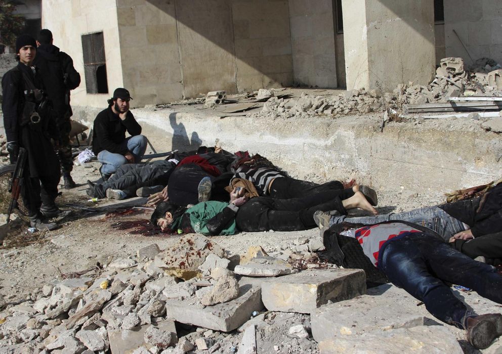 Foto: Combatientes rebeldes antes los cuerpos de yihadistas del ISIS ejecutados en Alepo (Reuters).