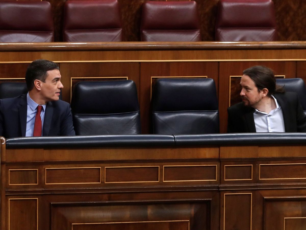 Foto: Pedro Sánchez y Pablo Iglesias conversan desde sus escaños en el Congreso. (EFE)