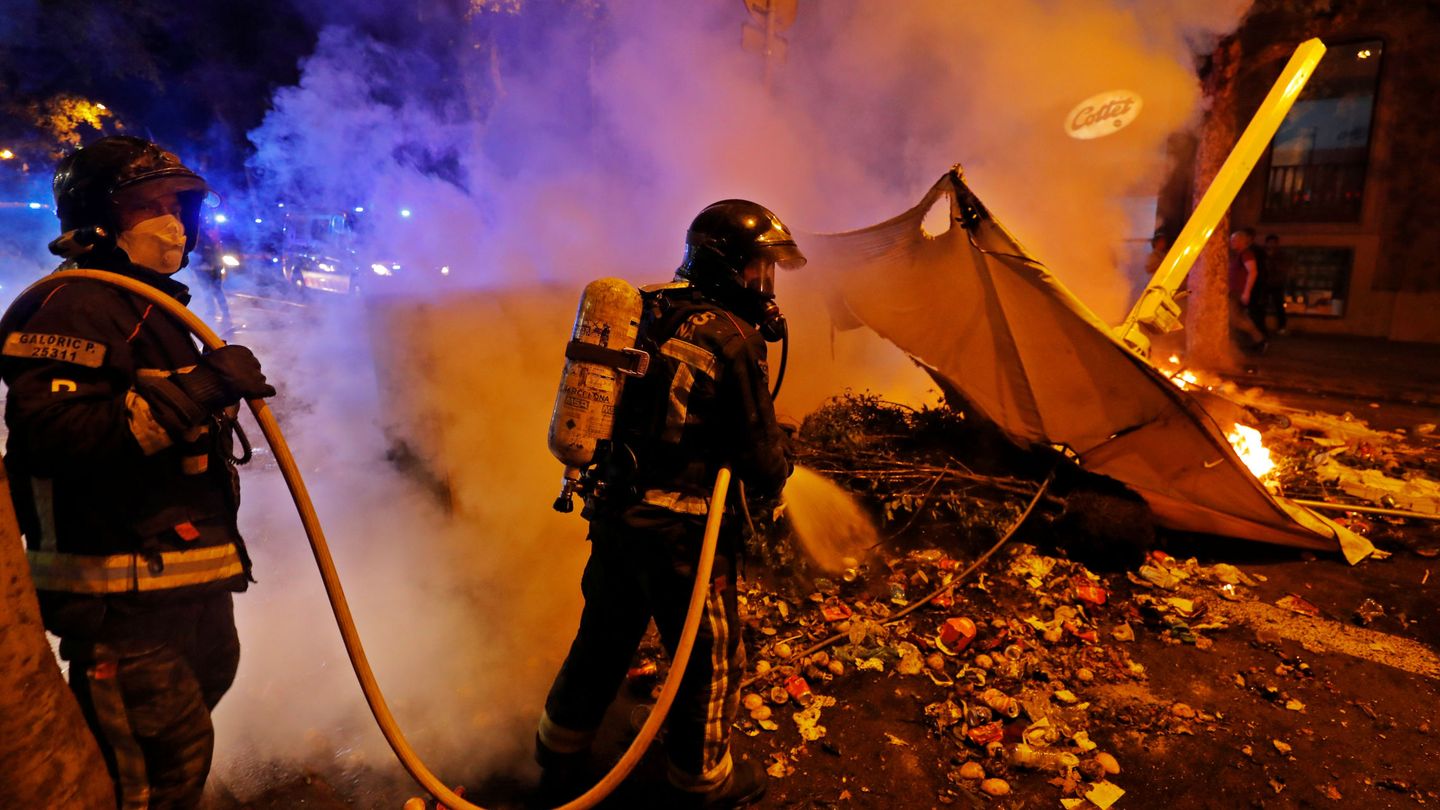Los bomberos apagan una barricada la pasada noche en Barcelona. (Reuters)