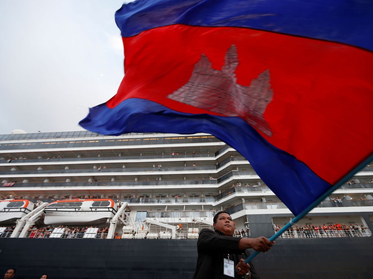 Foto: Un hombre ondea una bandera camboyana junto al MS Westerdam. (Reuters/Soe Zeya Tun)