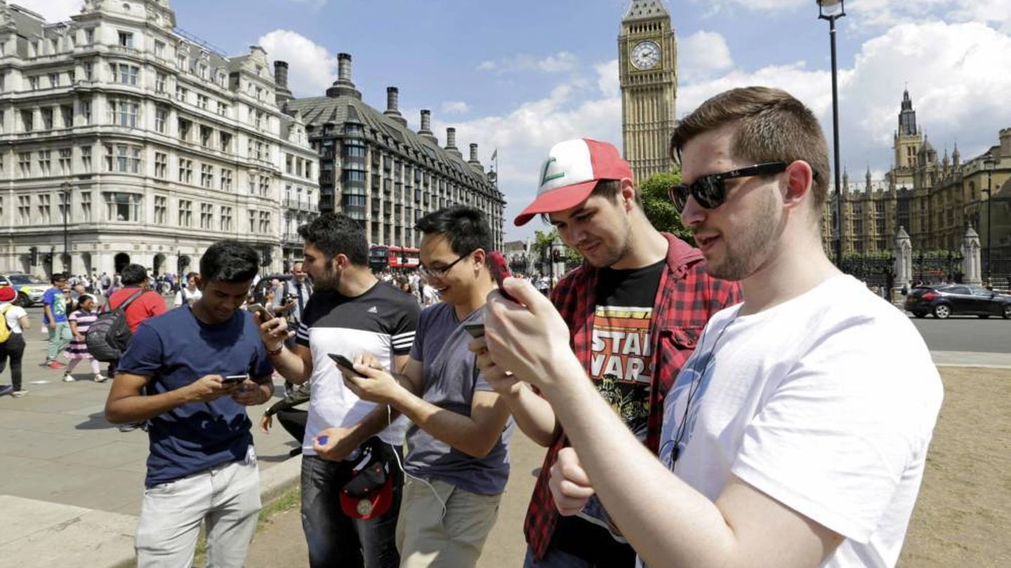 Varios chicos utilizan su móvil frente al Big Ben de Londres (Reuters)