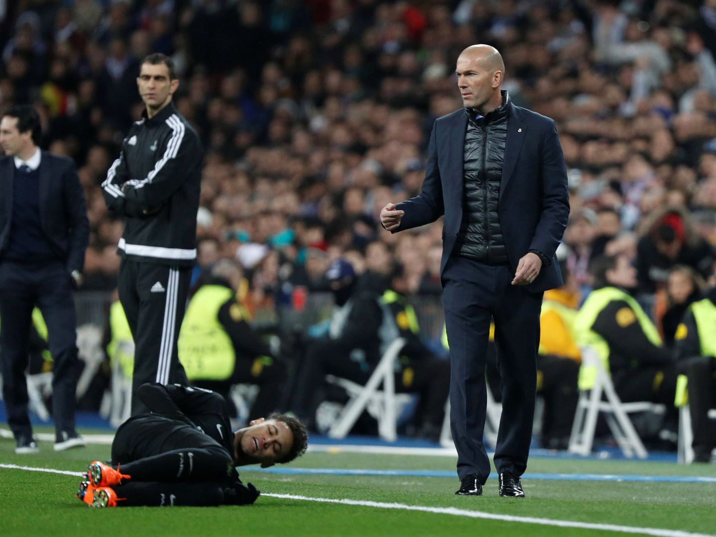 Neymar, caído en el suelo, con Zidane detrás, durante el Real Madrid-PSG de Champions. (Reuters)