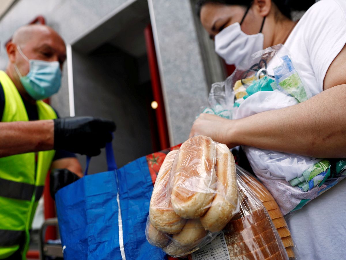 Foto: Un voluntario entrega alimentos donados en Madrid (REUTERS)
