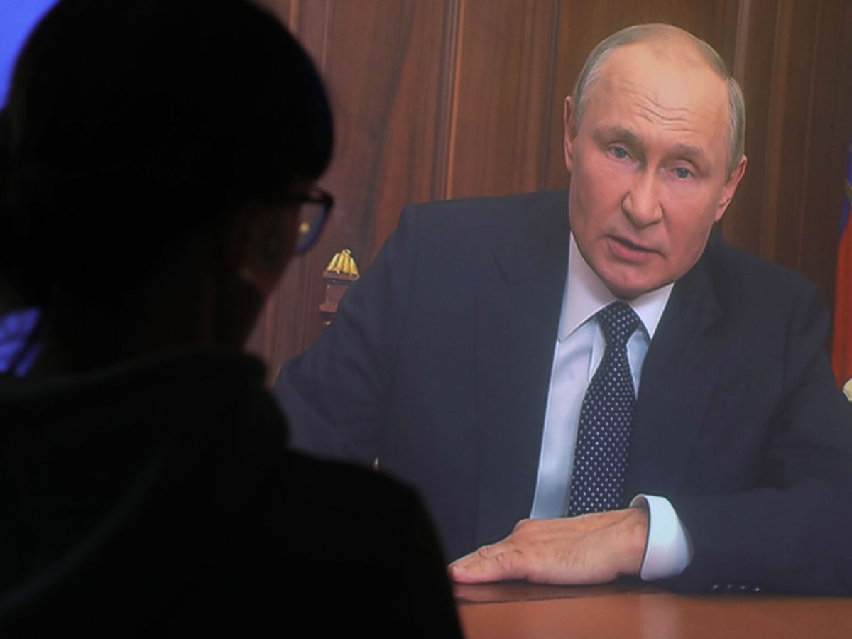 Foto: Una mujer observa el discurso televisado de Putin. (EFE/EPA/Maxim Shipenkov)
