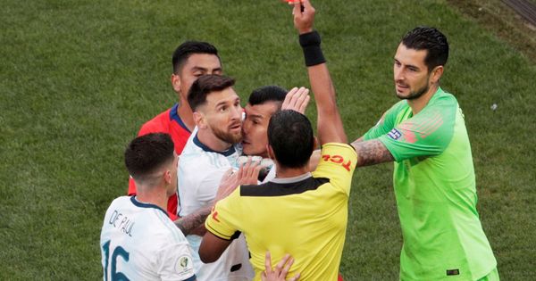 Foto: Messi, agarrado a Medel, ve cómo el árbitro les expulsa. (EFE)