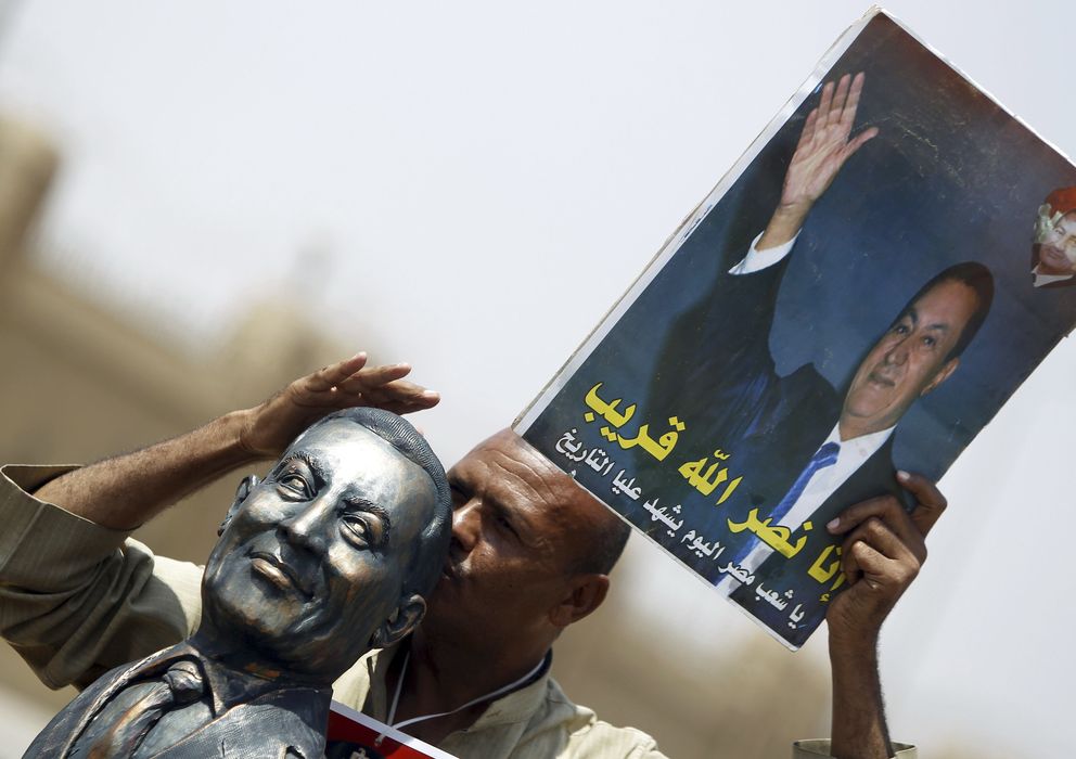Foto: Un seguidor del expresidente Mubarak besa su busto y sostiene un póster. (Reuters)