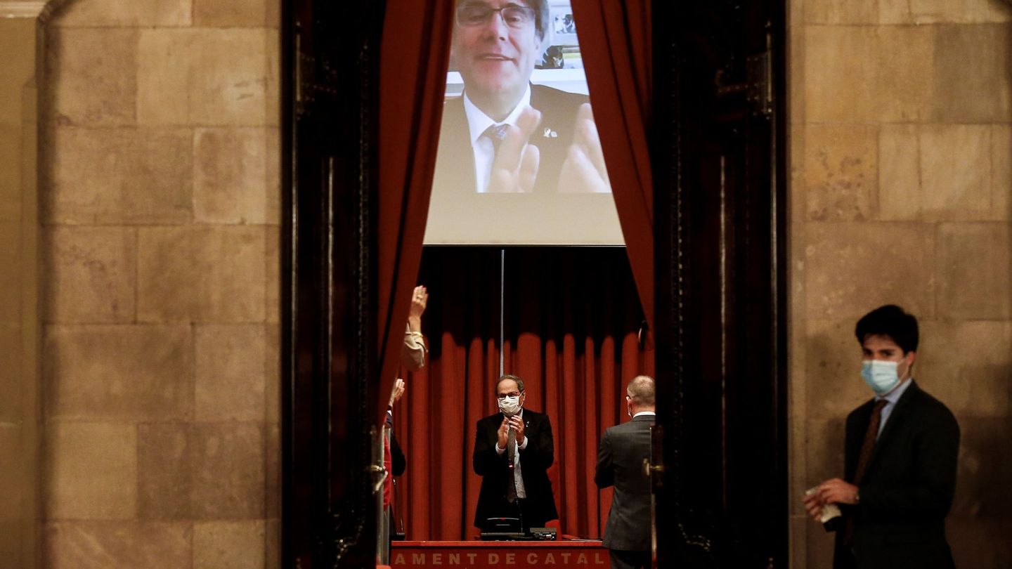 El expresidente de la Generalitat, Quim Torra, recibe el aplauso del expresidente Carles Puigdemont (en la pantalla). (EFE)