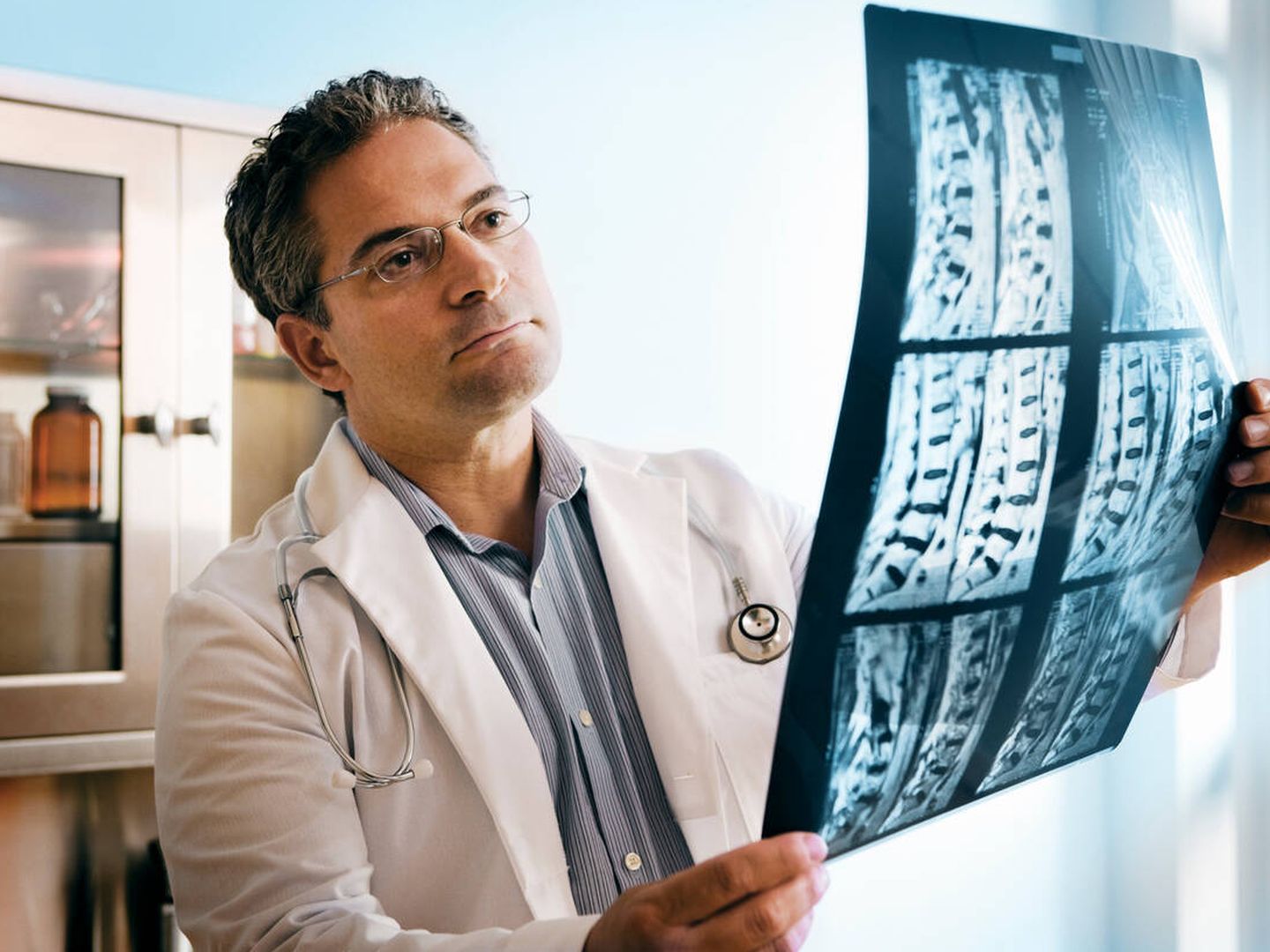 Un doctor evalúa una radiografía de columna. (iStock)