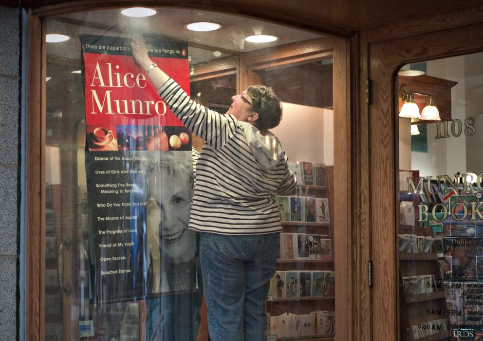 Foto: Una empleada de la Librería Munro, en Victoria (Canadá), coloca un póster de Alice Munro. (Reuters)