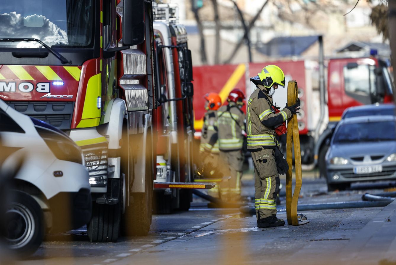 Varios bomberos recogen el material usado en la extinción del incendio en el edificio del barrio de Campanar de Valencia. (EFE/Miguel Ángel Polo) 