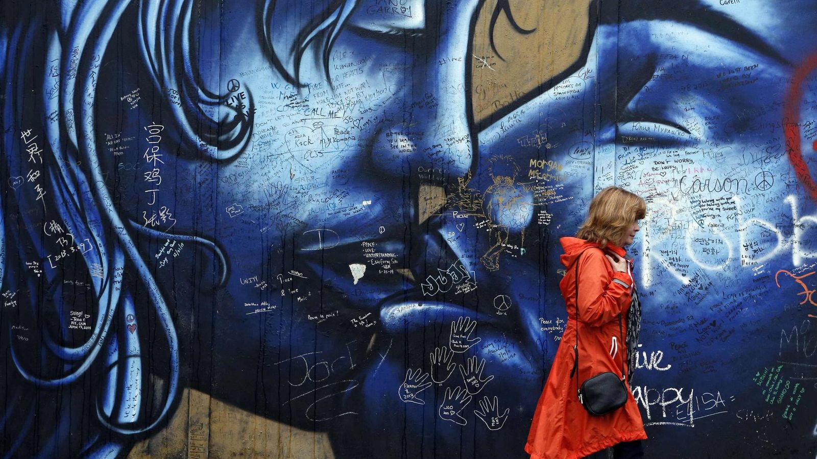 Una turista camina frente a un 'muro de la paz' en Irlanda del Norte. (Reuters)