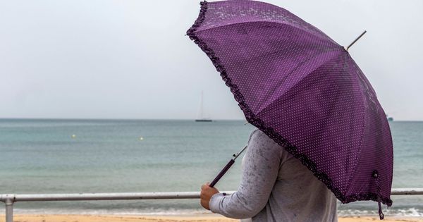 Foto: Una mujer se protege de la lluvia en Palma de Mallorca. (Efe)