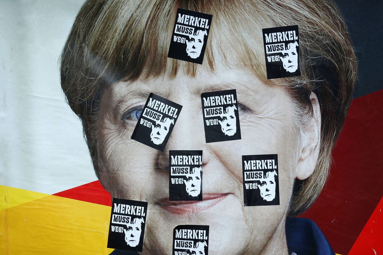 Un cartel electoral de la canciller con pegatinas que rezan: 'Merkel debe irse', en Fráncfort. (Reuters)