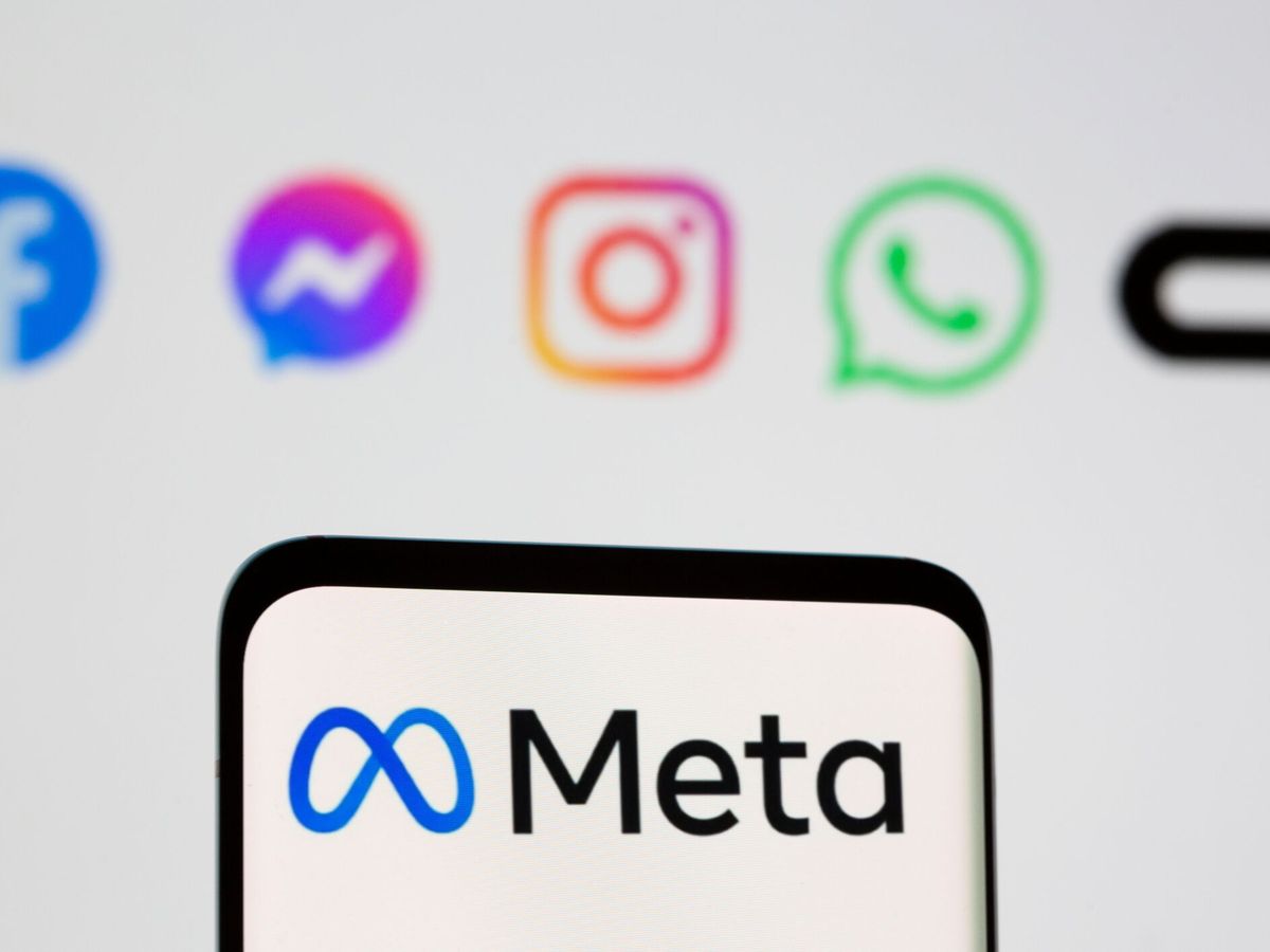 Foto: Facebook's new rebrand logo meta is seen on smartpone in front of displayed logo of facebook, messenger, intagram, whatsapp, oculus in this illustration taken