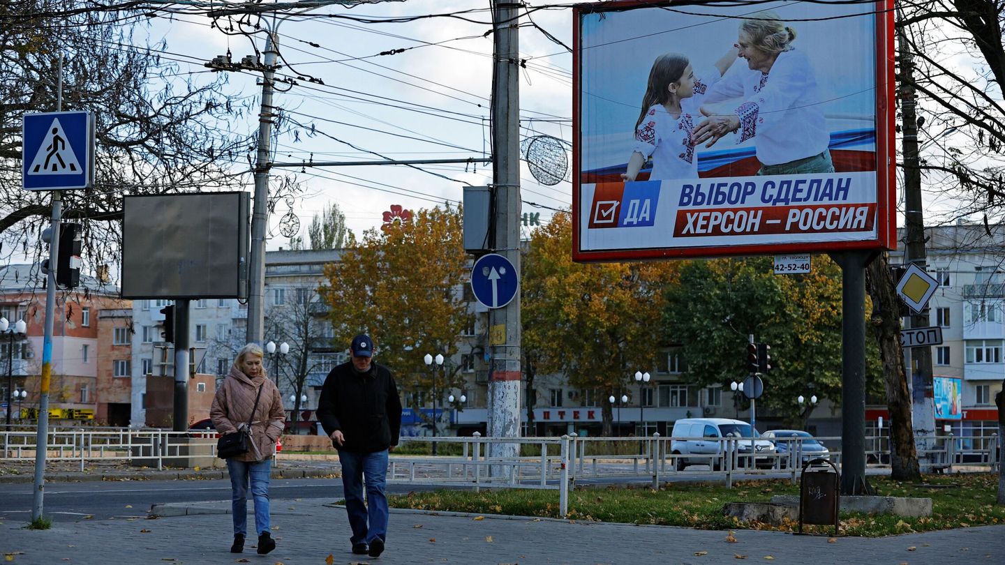 Ciudadanos de Jersón delante de un cartel en Jersón que proclama la pertenencia de la ciudad a Rusia. (Alexander Ermochenko/Reuters)