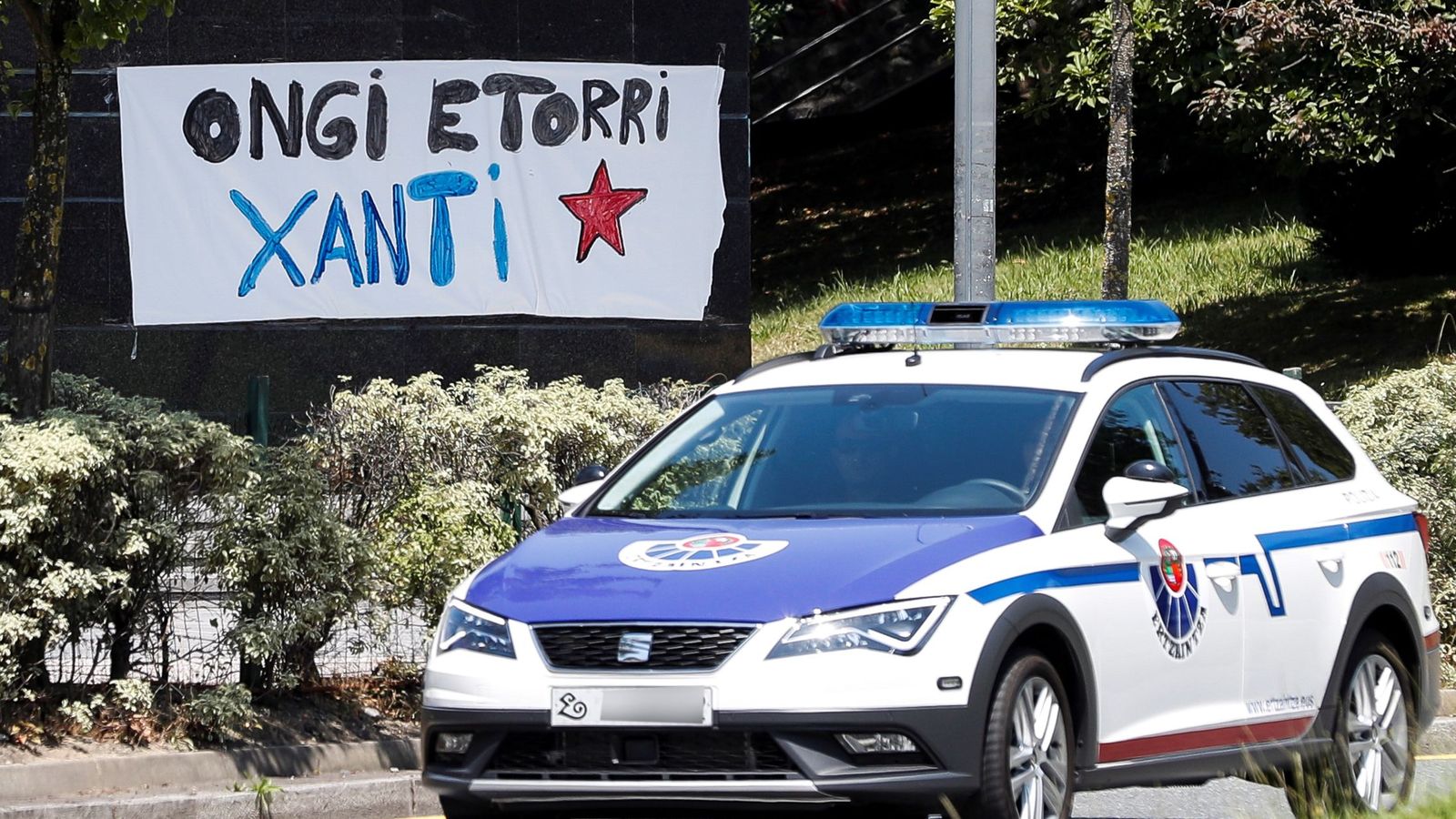 Foto: Una pancarta da la bienvenida a Santi Potros al paso de una patrulla de la Ertzaintza en su localidad natal de Lasarte-Oria. (EFE)