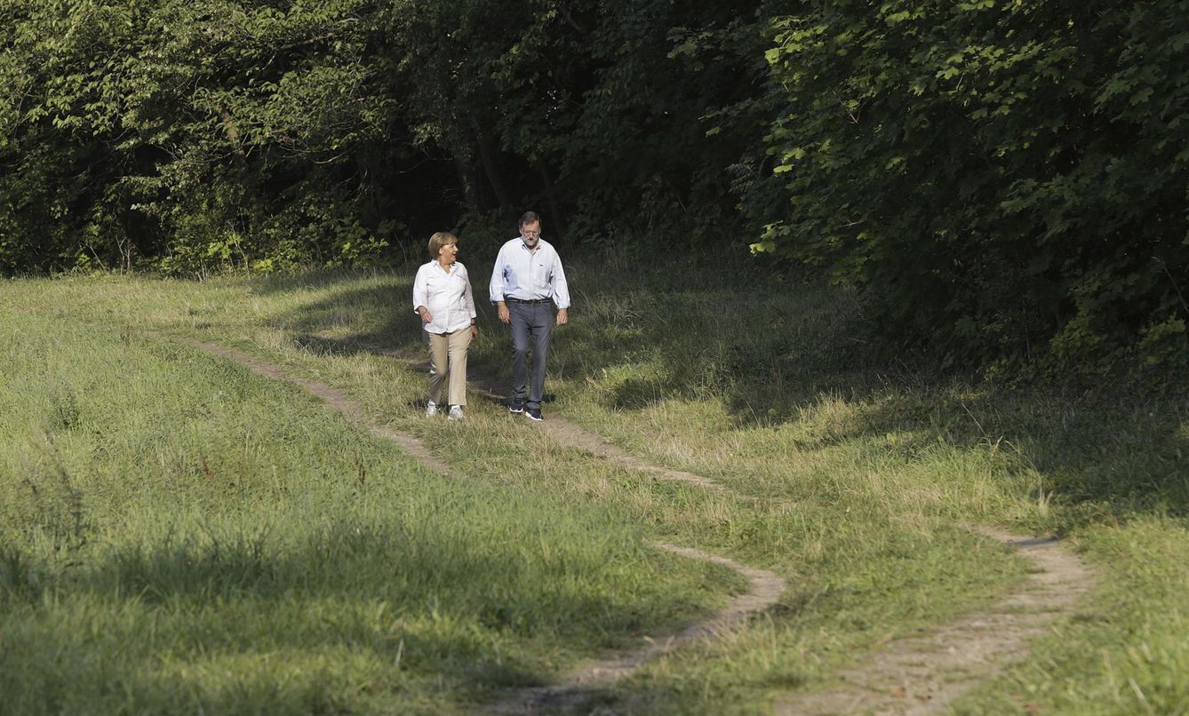Merkel y Rajoy durante su paseo. (EFE)
