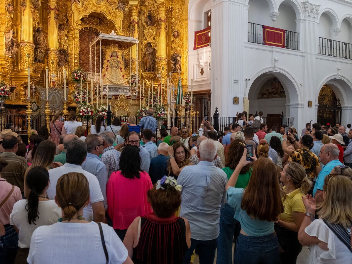 Foto: Cientos de personas rezan ante la imagen de la Virgen del Rocío en el Santuario ubicado en la aldea almonteña de El Rocío (Huelva). (EFE/Julián Pérez)
