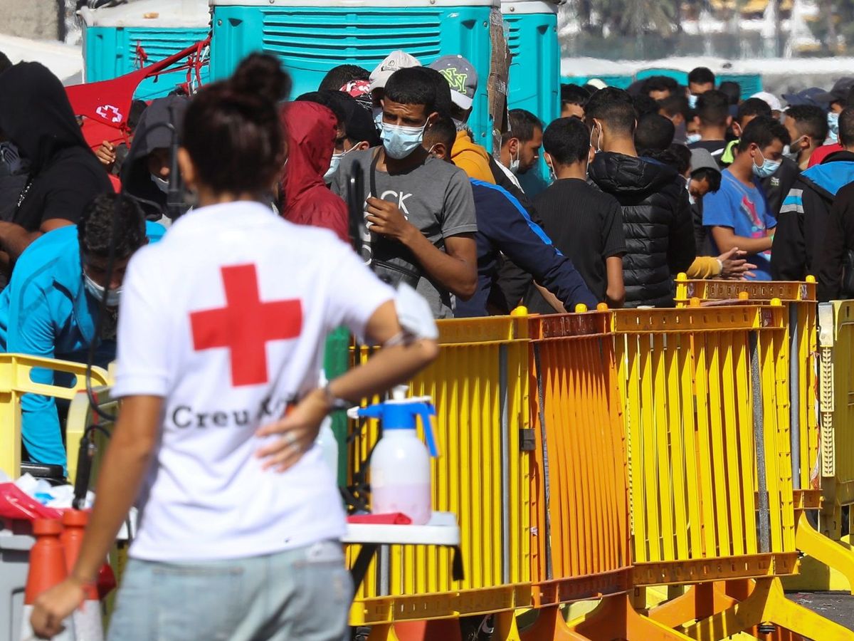 Foto: Una voluntaria de Cruz Roja junto a varios inmigrantes. (EFE)
