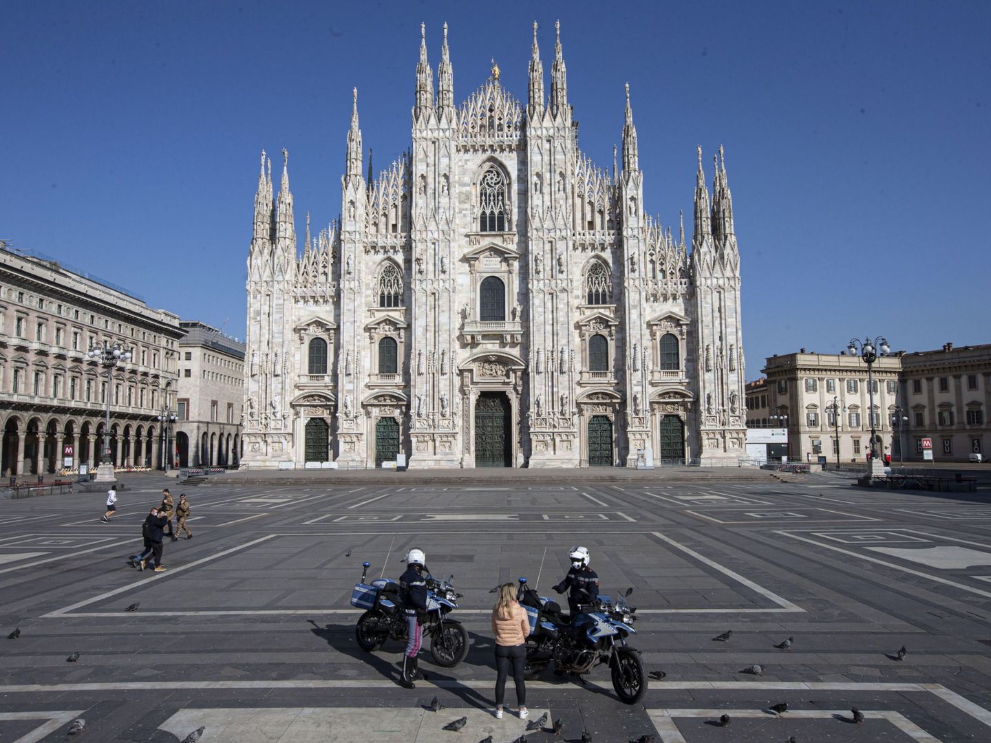 Unos policías hablan con una mujer en Milán, tras el confinamiento general ordenado por el Gobierno italiano. (EFE)