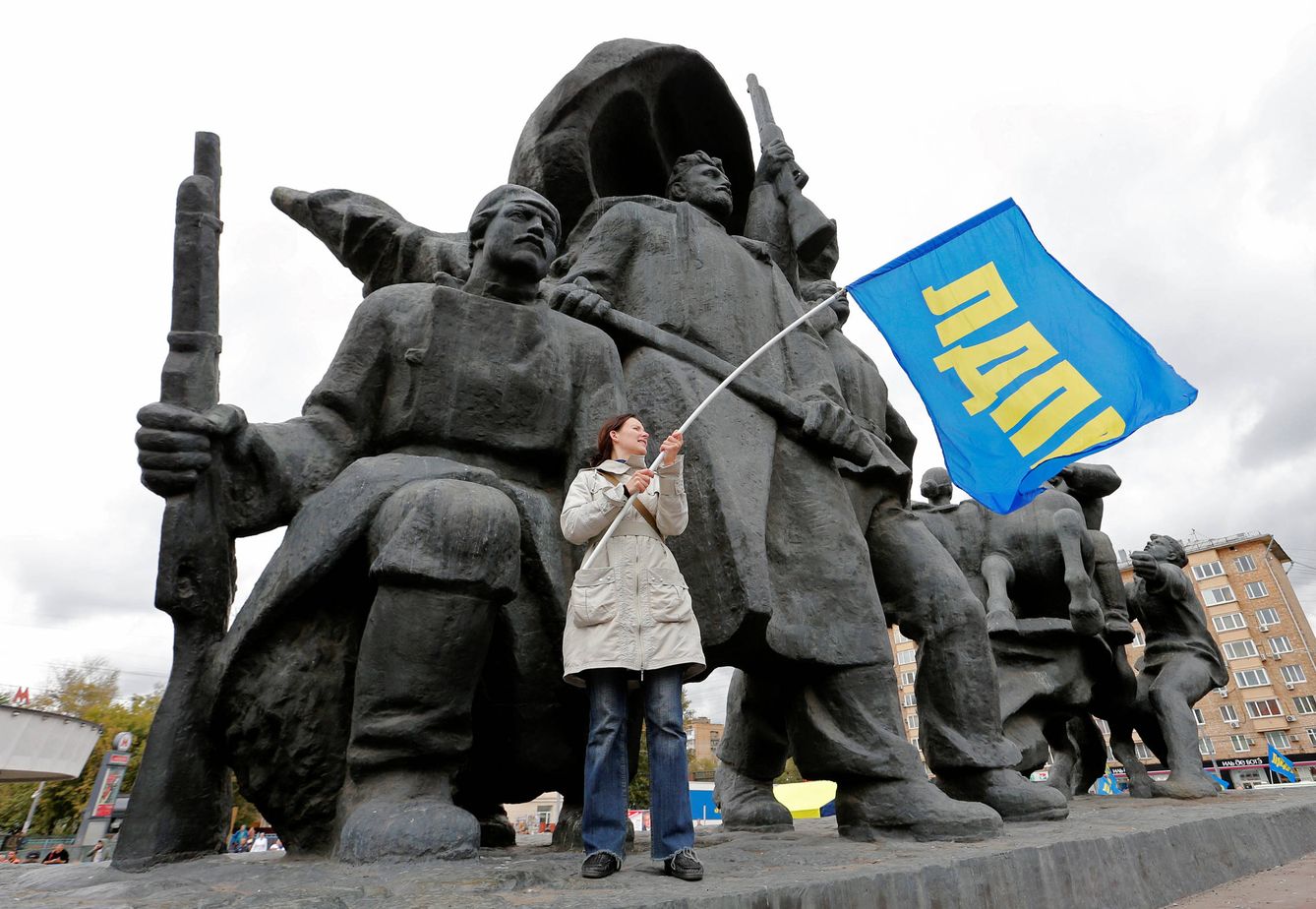 Una mujer ondea una bandera del Partido Liberal Democrático de Rusia durante un evento de campaña en Moscú. (Reuters)