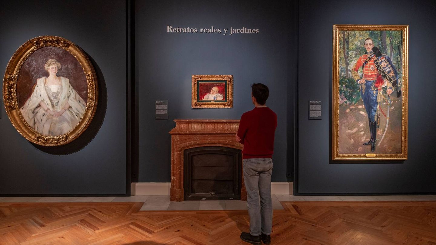 Un hombre contempla los retratos de la reina Victoria Eugenia y de Alfonso XIII realizados por Sorolla.