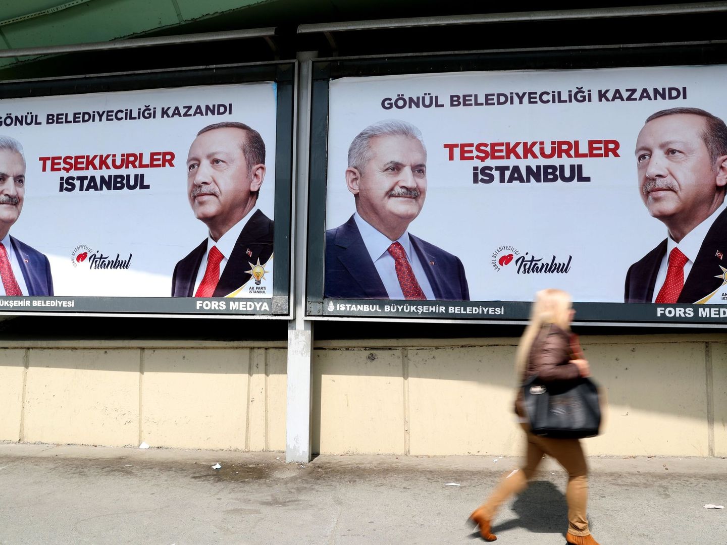 Gente pasea delante de carteles electorales del presidente turco, Recep Tayyip Erdogan, y del candidato del partido Justicia y Desarrollo (AKP), Binali Yildirim, en Estambul. (EFE)