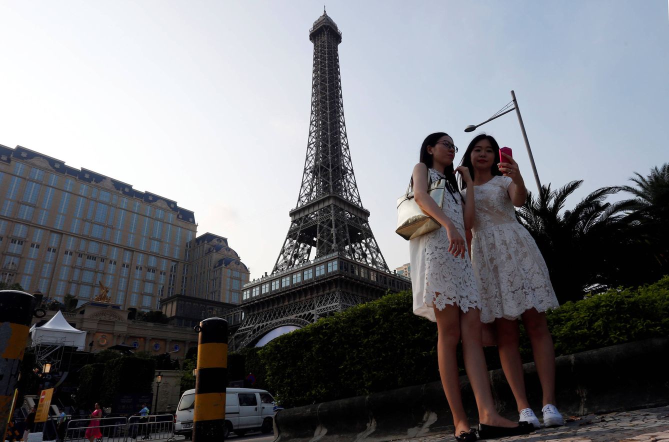 Turistas se fotografían ante un réplica de la Torre Eiffel en Macao. (Reuters)