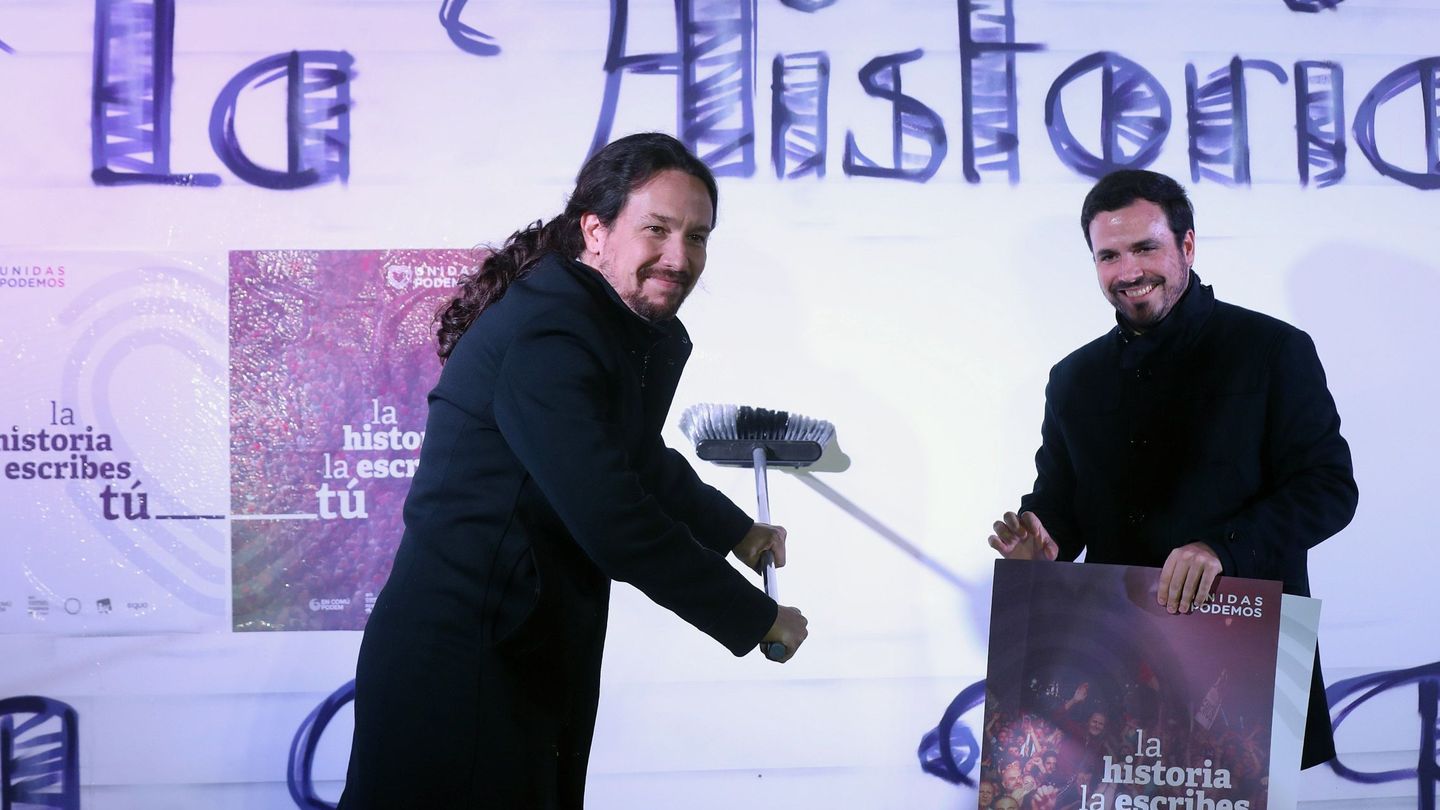 Pablo Iglesias (i) y Alberto Garzón, durante la tradicional pegada de carteles. (EFE)