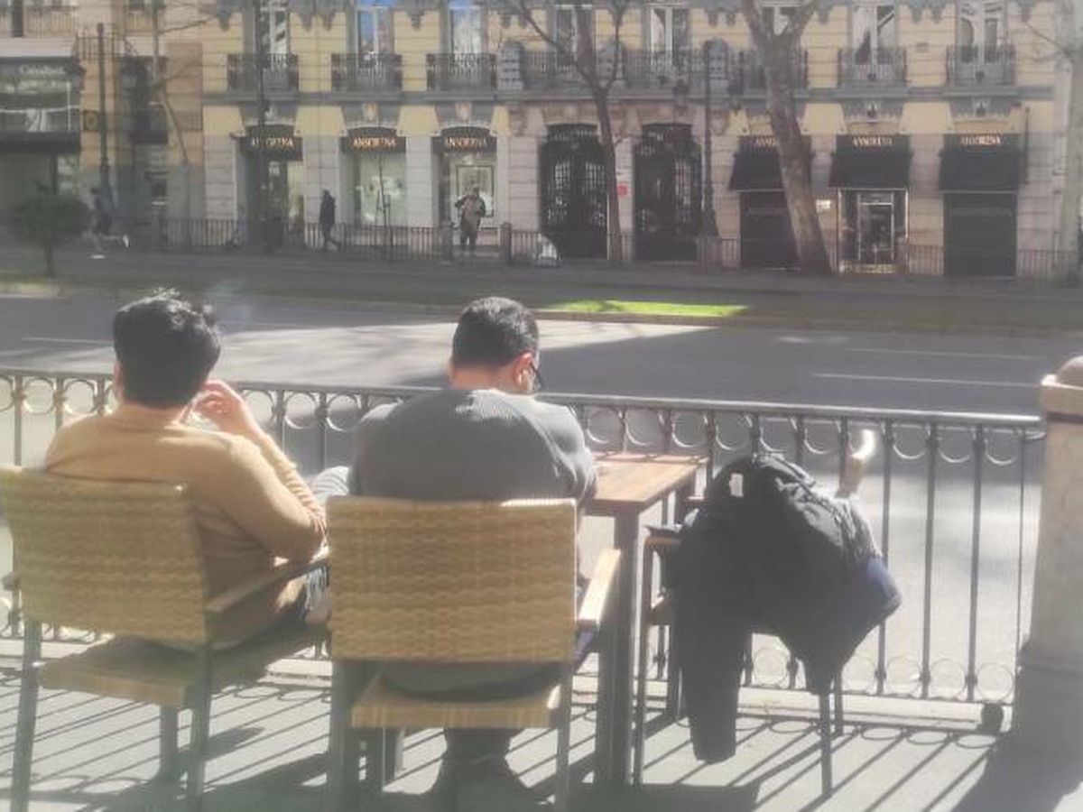 Foto: Dos turistas franceses contemplan desde un bar en la calle de Alcalá de Madrid, en el tramo entre Puerta de Alcalá y Cibeles, la zona que Almeida plantea reconvertir en bulevar. (L.B.)
