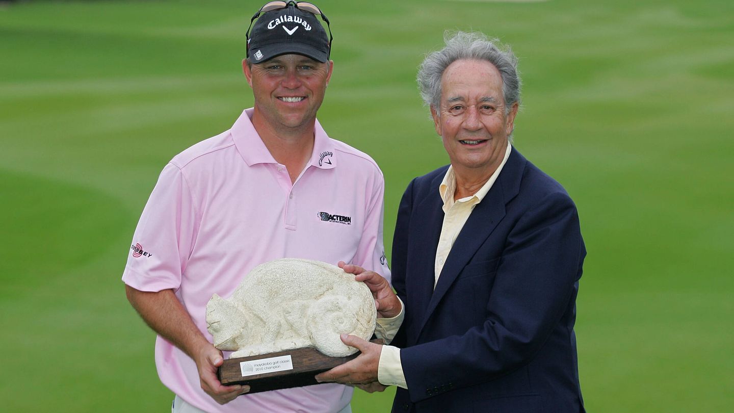 El empresario entregando un trofeo de golf a Cameron Beckman. (Getty)