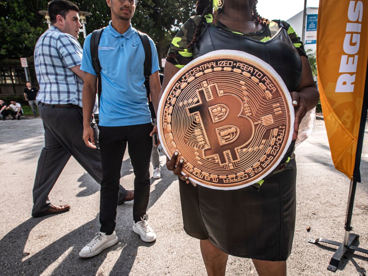 Foto: Una persona sostiene un enorme bitcoin. (EFE/Giorgio Viera)