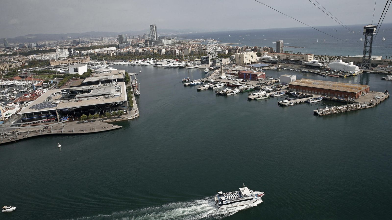 Foto: Un barco turistico se aleja del puerto de Barcelona. (EFE)