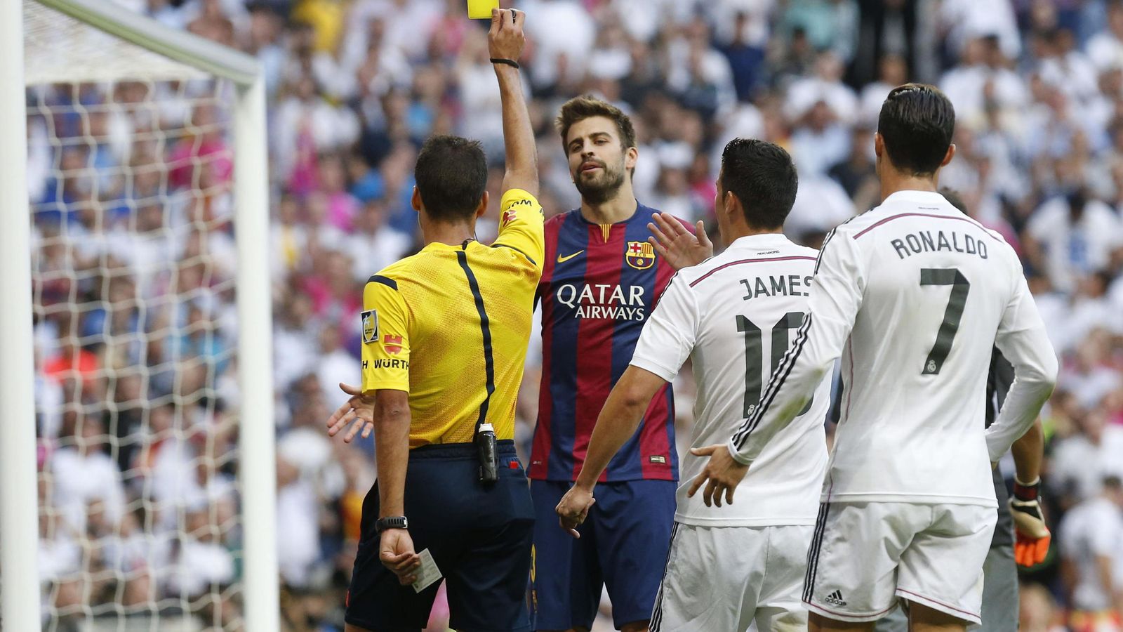 Foto: El árbitro saca tarjeta amarilla a Gerard Piqué (c) ante James Rodríguez (2d) y Cristiano Ronaldo en un partido de Liga. (EFE)