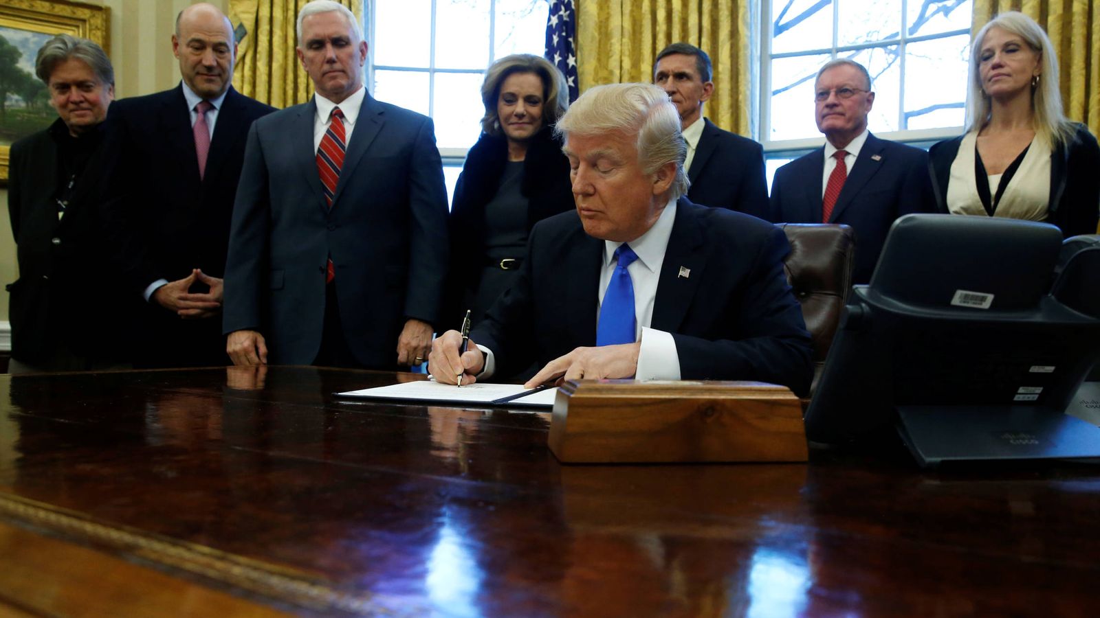 Foto: Trump firma un memorando sobre el Estado Islámico rodeado de su equipo, en la Casa Blanca, el 28 de enero de 2017. (Reuters)