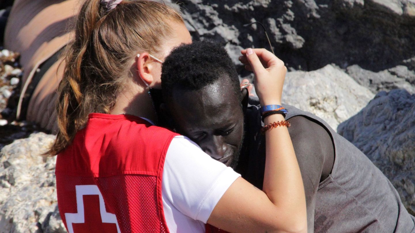 Una trabajadora de Cruz Roja abraza a un migrante que ha logrado llegar a Ceuta (EFE)